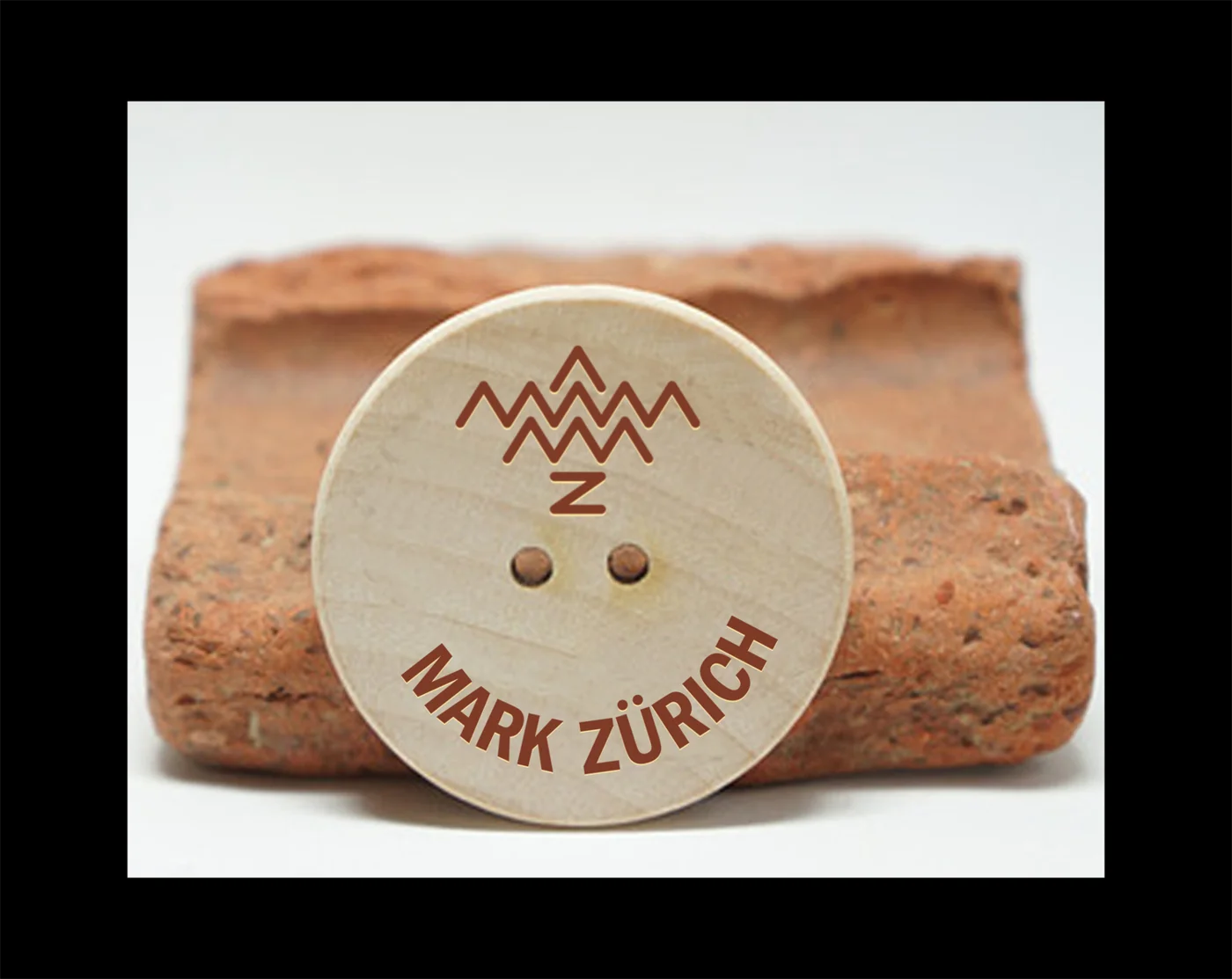 Mark Zürich symbol and wordmark mockup on a wooden garment button