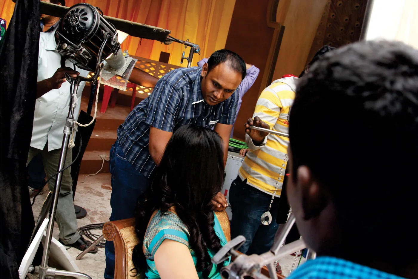 Crew adjusting studio lighting rig on a commercial shoot set