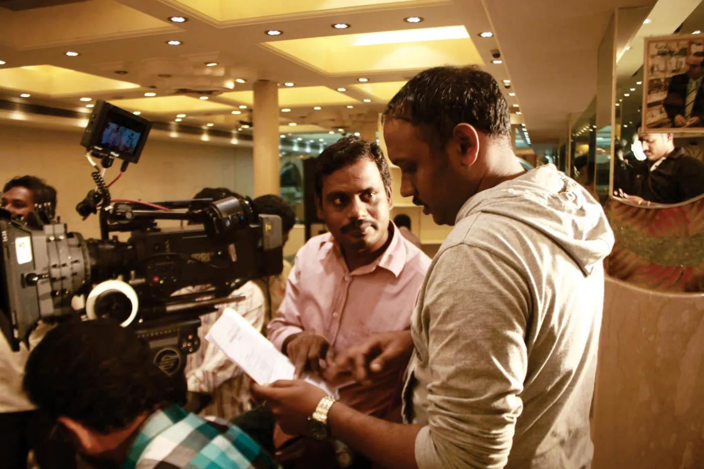 Director reviewing the shot on a laptop with crew during a jewellery ad film shoot