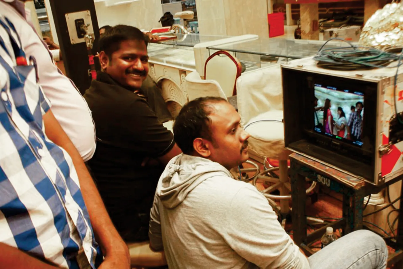 Director and crew reviewing playback footage on set